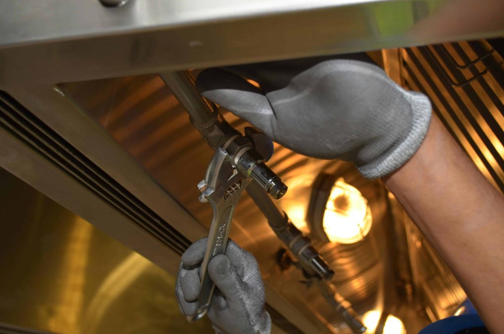 plumber tightening pipe with wrench