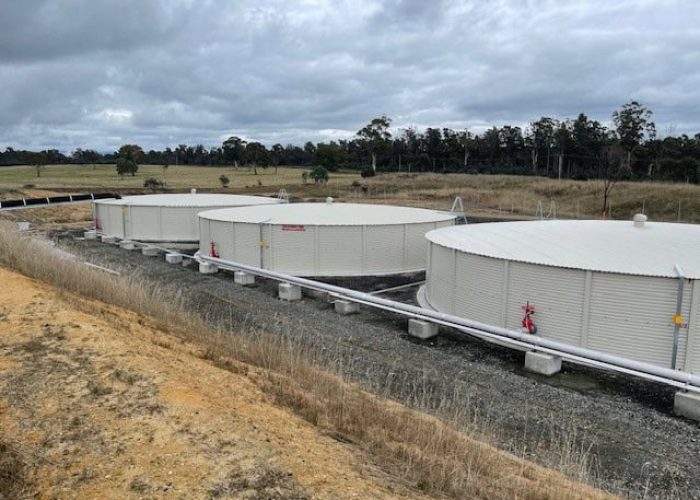 triple water tank setup on countryside with clear sky - Angle 2