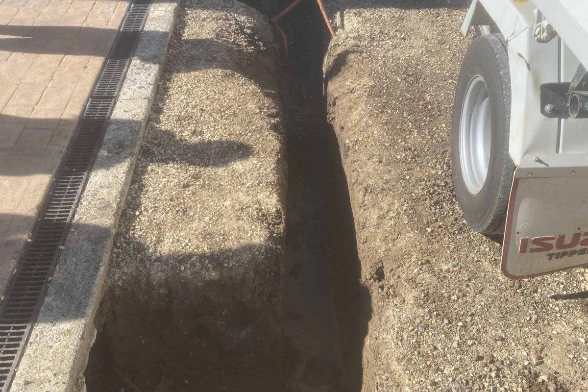 Deep trench for drainage pipe installation in backyard - Angle 2